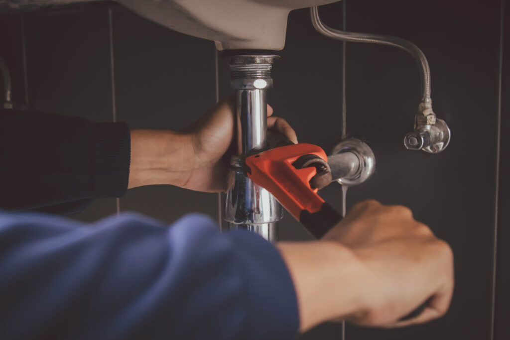 plumber at work in a bathroom, plumbing repair service , fix water plumbing leaks, replace the kitchen sink drain